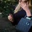 Blond lady is smoking white cigarette outdoors