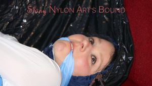 Lucy tied, gagged and hooded on a sofa with tape wearing a sexy blue rainwear combination (Pics)