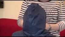 Jill tied, gagged and double hooded on a chair wearing shiny nylon shorts and two shiny nylon rain jackets (Video)