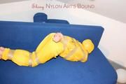Archive girl tied and gagged by using tape on a sofa wearing an yellow rainsuit (Pics)