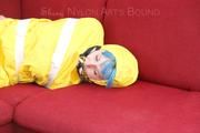 Mara tied, gagged and hooded with tape on a red sofa wearing shiny yellow rainwear (Pics)