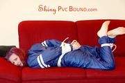 Mara tied and gagged on a sofa wearing a shiny blue PVC sauna suit (Pics)