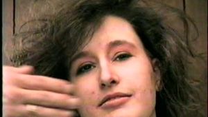 ERICA IS HANDGAGGED, BALL-GAGGED & TIED WITH BLACK ROPE TO A SOFA BED (D33-3)