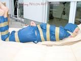 Beautiful archive girl in a blue shiny nylon rainsuit tied and gagged with tape on a sunlounger (Pics)