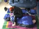 02:45 Min. video with a girl tied and gagged in a skisuit and a big shiny nylon bag to lie in from our archive