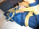 One of our archive girls bound and gagged in a blue shiny rainsuit 