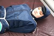 Jill tied, gagged and hooded in bed wearing a sexy green shiny nylon shorts and a shiny rain jacket (Video)