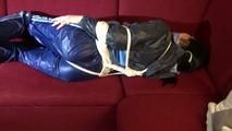 Lucy tied and gagged on a red sofa wearing a supersexy blue shiny nylon pants and a blue rain jacket (Video)