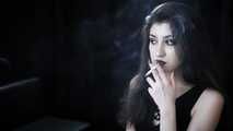 Goth girl with black eyes occasionally prefers dragging a 120mm cigarette