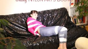 Mara tied, gagged and hooded with tape on a sexy black covered sofa wearing a supersexy grey rain pants and a pink rain jacket (Pics)