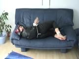 Jill tied and gagged on a blue sofa wearing sexy shiny nylon rainwear (Video)