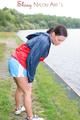 Sexy archive girl walking on a lake wearing a sexy shiny nylon shorts and an oldschool rain jacket (Pics)