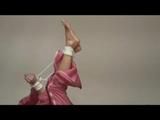 Pia tied and gagged on bed wearing a shiny pink rainwear (Video)
