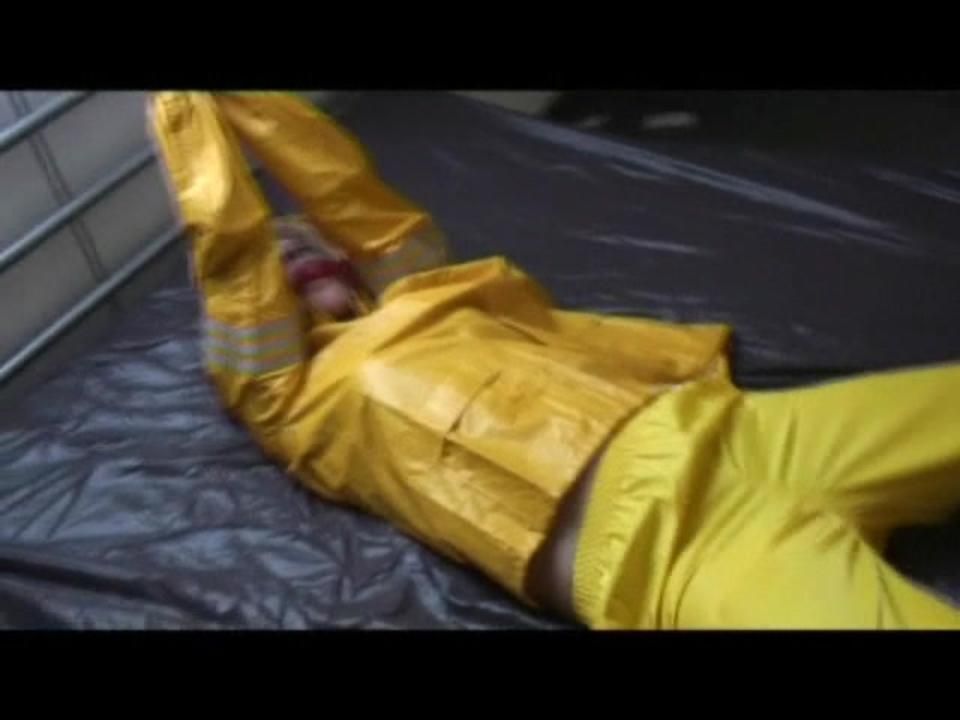 Pia Tied And Gagged In An Yellow Rainsuit On Bed (Video)