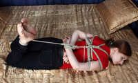 Ballgagged barefoot Tammy in red t-shirt and black jeans, hogtied with hemp rope
