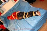 one of our archive girls tied and gagged in shiny nylon rainwear