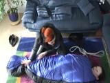 02:45 Min. video with a girl tied and gagged in a skisuit and a big shiny nylon bag to lie in from our archive
