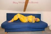 Archive girl tied and gagged by using tape on a sofa wearing an yellow rainsuit (Pics)