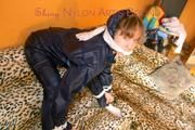 Leoni tied and gagged on a sofa wearing a sexy shiny nylon pants and a rain jacket (Pics)