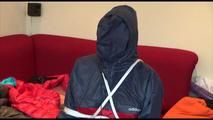 Jill tied, gagged and double hooded on a chair wearing shiny nylon shorts and two shiny nylon rain jackets (Video)