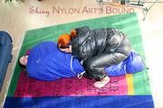 An archive girl tied and gagged in a sleepingsack by Jill on the floor both wearing shiny down jackets (Pics)