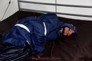Simone tied and gagged in a shiny nylon rainsuit and a shiny nylon cape