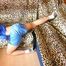 Leonie wearing a lightblue shiny nylon shorts and a blue rain jacket posing on a leopard sofa (Pics)