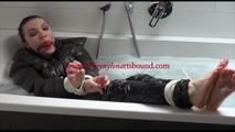 Jill tied and gagged in a bath tub wearing shiny nylon rain pants and a shiny down jacket (Video)