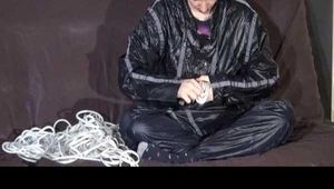 Watching Mara wearing sexy black rainwear during sorting her ropes for the next bondage session (Video)