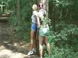 An archive girl tied and gagged on a tree by Jill both wearing shiny nylon shorts (Video)