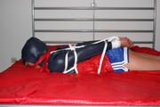 Alina bound in blue shorts and a shiny jacket