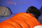 Mara wearing a sexy black down pants and an orange down jacket while lolling and reading on the sofa (Pics)