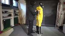 Watch Lady M bound in a yellow Rainsuit wearing a latex Hood and a Gasmask