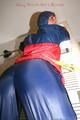 Stella tied, gagged and hooded on an radiator wearing a shiny red/blue rain combination (Pics)