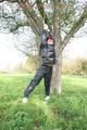 Jill tied and gagged outdoor on a tree wearing a sexy black downjacket and a black rain pants (Pics)