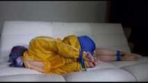 Mara with blue hairs wearing a sexy blue/yellow shiny nylon shorts and a yellow rain jacket tied and gagged with ropes and a ball gag on the sofa (Video)