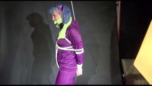 MARA tied and gagged overhead with ropes and a cloth gag wearing a super sexy super shiny purple rainsuit and blue rubber boots (Video)