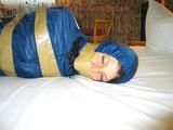One of our archive girls bound and gagged in a blue shiny rainsuit 