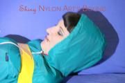 Mara tied and gagged with tape on a sofa wearing a supersexy shiny blue rain pants and a grren rain jacket (Pics) 
