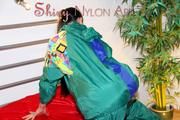 Lucy putting on linen on bed wearing supersexy green shiny nylon rainwear (Pics)