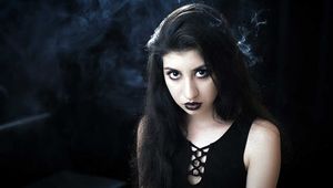 Goth girl with black eyes occasionally prefers dragging a 120mm cigarette