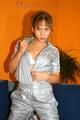 Leonie posing on a sofa wearing a grey adidas shiny nylon rainwear (Pics)