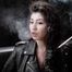 Dark-haired goddess experimenting with a cigarette holder while posing on camera