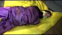 Lucy tied, gagged and hooded on bed on a bar wearing sexy purple rainwear (Video)