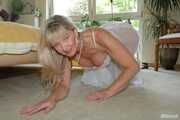 Busty blonde Marlen posing in a white negligee in the bedroom
