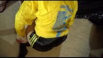 Lucy tied and gagged on a sofa wearing a sexy black shiny nylon shorts and a yellow rain jacket (Video)