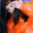 Mara wearing a sexy black down pants and an orange down jacket while lolling and reading on the sofa (Pics)