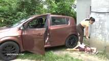 Mistress Jenna stands on the slave with a car while smoking in the slave's mouth A