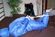 Jill tied, gagged and hooded on bed wearing a supersexy supershiny lightblue downwear (Pics)