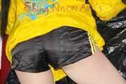 Lucy wearing a sexy black/yellow shiny nylon shorts and a yellow rain jacket preparing her sofa with a special cloth to enjoy it (Pics)